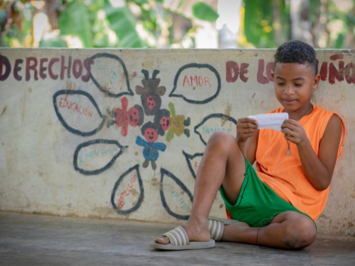 Niño de Colombia ante mural sobre derechos de los niños