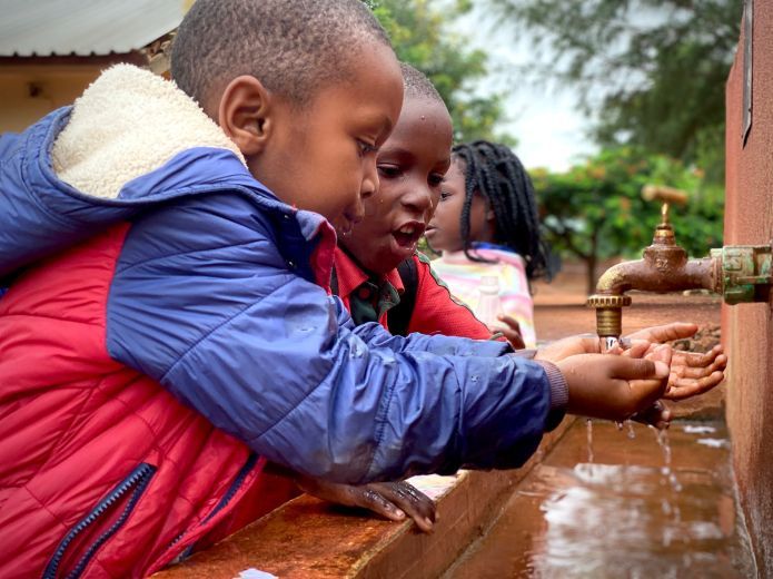 Niños de Mozambique con grifo de agua
